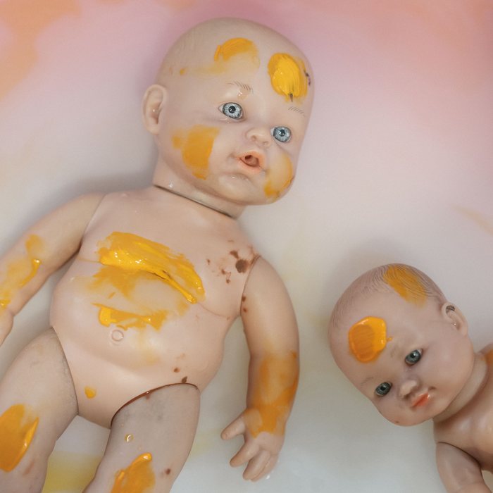 Baby dolls covered in paint, ready to be washed