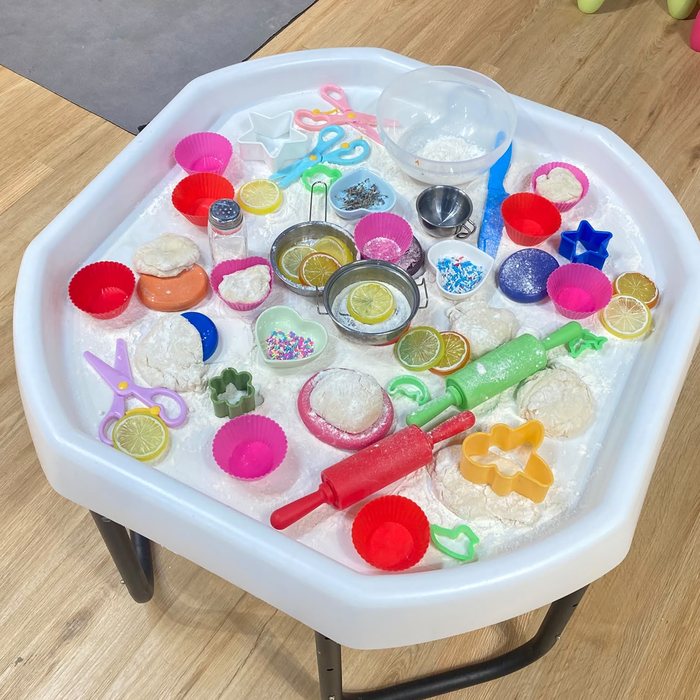 Sensory tray with flour, dough, rolling pins and cookie cutters