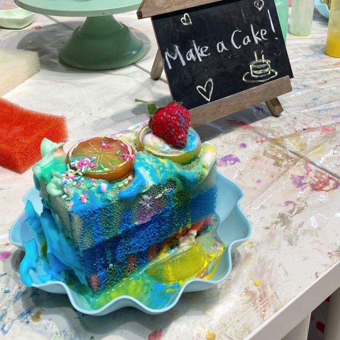 Sponge cake decorated with coloured foam, sprinkles and a strawberry